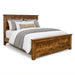 Handstone Adirondack King Panel Bed in wormy maple with a Sawmill Harvest finish, featuring a substantial framed headboard and footboard, natural wood grain with a rough-sawn textured finish, rustic character, and dark metal accents.