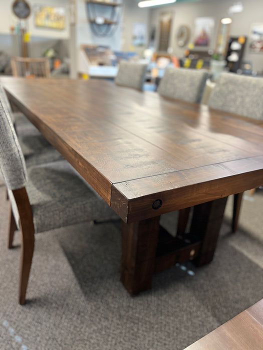 Close-up view of the Balmoral dining table top in solid wormy maple with a rich Mocha stain, highlighting the detailed wood grain, rough-sawn finish and substantial tabletop edge.