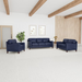 Hayward living room collection featuring a navy blue genuine top grain leather sofa, loveseat and armchair, arranged in a bright modern living room. The fully upholstered seating has clean, boxy silhouettes, cushioned backs and seats, broad arms and tapered dark wood legs. The room features exposed wood ceiling beams, a light neutral floor and walls, a vertical wood accent wall, framed artwork, a potted plant and a small side table with lamp.