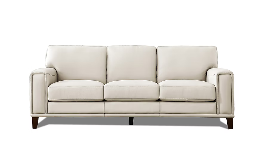 Hayward sofa fully upholstered in a vanilla coloured genuine top grain leather, featuring a clean, low-profile silhouette with three cushioned back and seat sections, broad square arms and tapered dark wood legs.