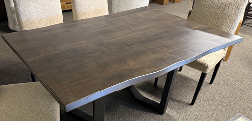 Close-up of the Pemberton dining table in solid wormy ambrosia maple, featuring a dark Sawmill Moose finish, distinctive wood character, faux-live edge, and angular black metal base.