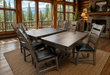 rustic dining room featuring a solid wood rectangular table with a trestle-style base, surrounded by 6 matching wooden chairs with dark upholstered seats.