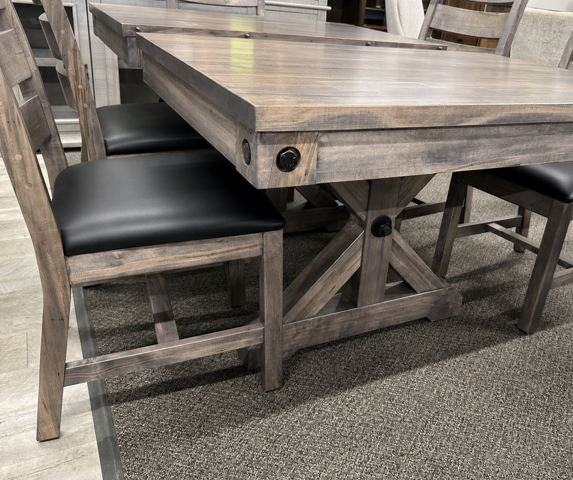 rustic dining table featuring a trestle-style base, and matching wooden chairs with dark upholstered seats